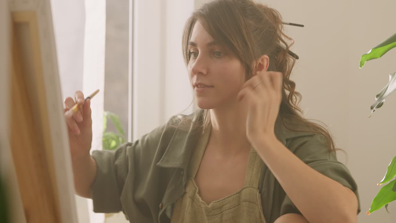 mujer artista pintando en casa