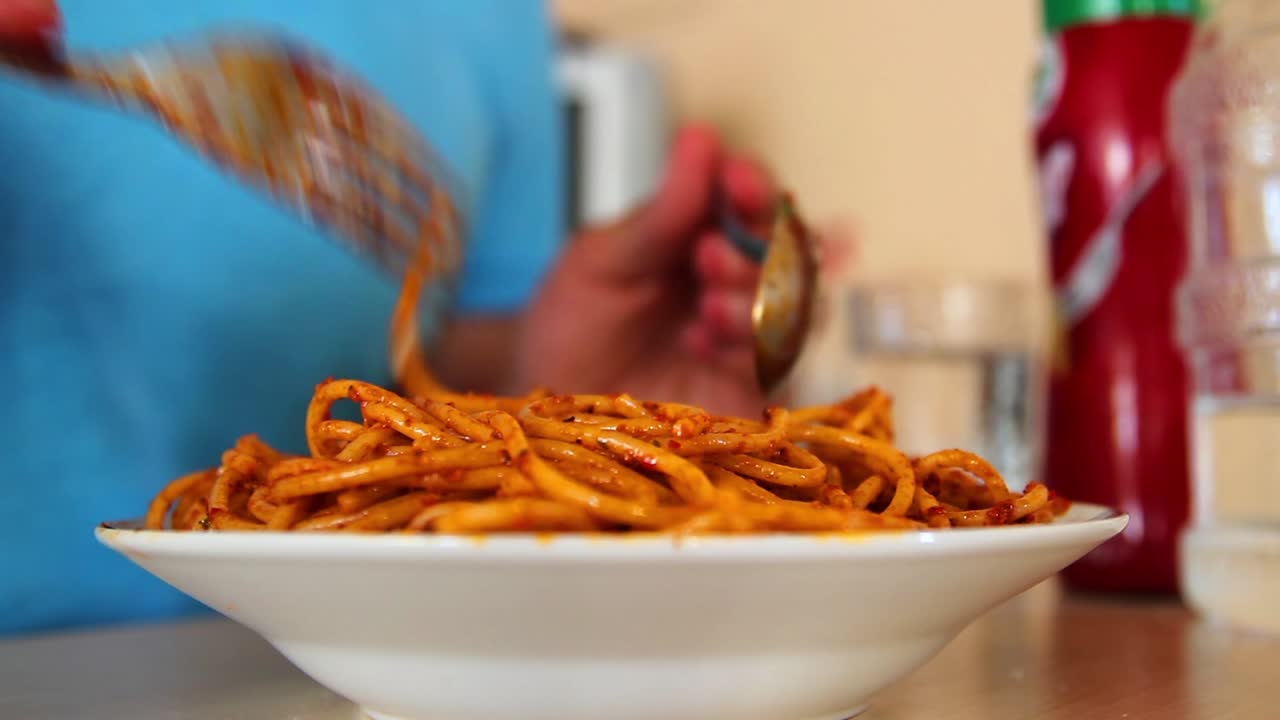 파스타를 먹고 있는 혼자 있는 젊은 남자