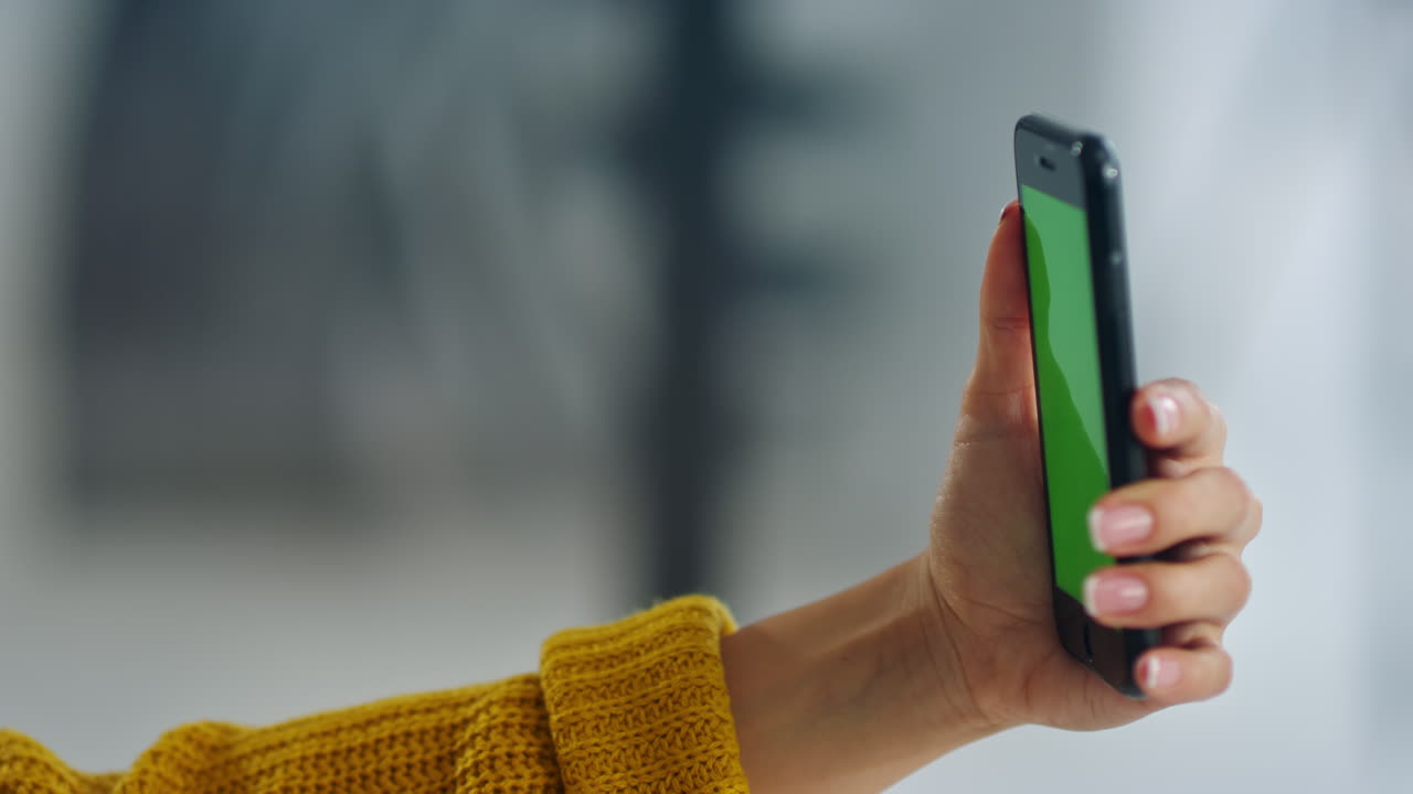 Mani di donna in primo piano che scattano un selfie con il cellulare. La donna è in posa per il selfie.