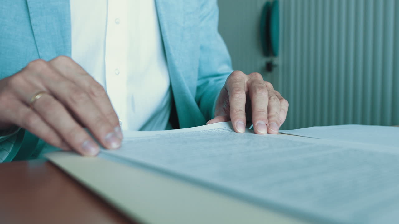 Close up of hands of young businessman lawyer or man working with documents in office looking