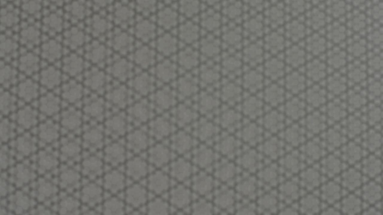 Two pieces of perforated metal plates moving in front of each other and forming abstract moiré patterns