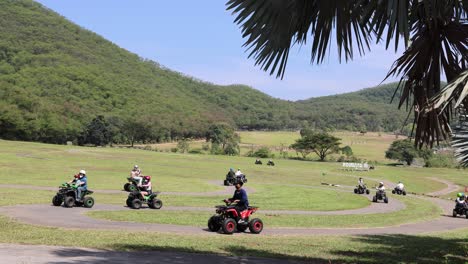 grupo de atvs montando a través de un valle verde