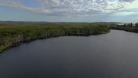 Stand-up-Paddle-En-El-Lago-Ainsworth---Agua-De-árbol-De-Té-En-El-Extremo-Norte-Del-Desfile-Pacífico-En-Lennox-Head---Nsw,-Australia---Disparo-De-Dron-Ascendente