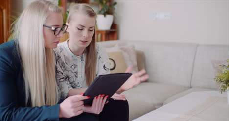 Two-Women-Working-On-A-Project-On-Digital-Tablet-At-Home-Office-4