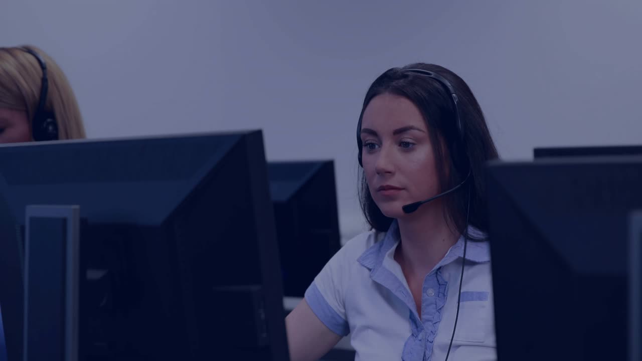 Support agent seeing monitor alert, adjusting headset responding to call while data overlays rising