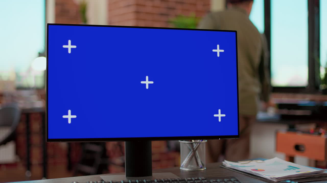 Nobody at desk with greenscreen template on computer monitor