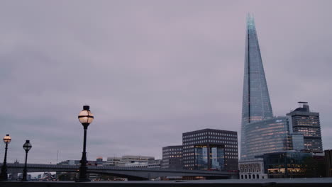 a wide shot of the shard and london bridge, with traffic passing by