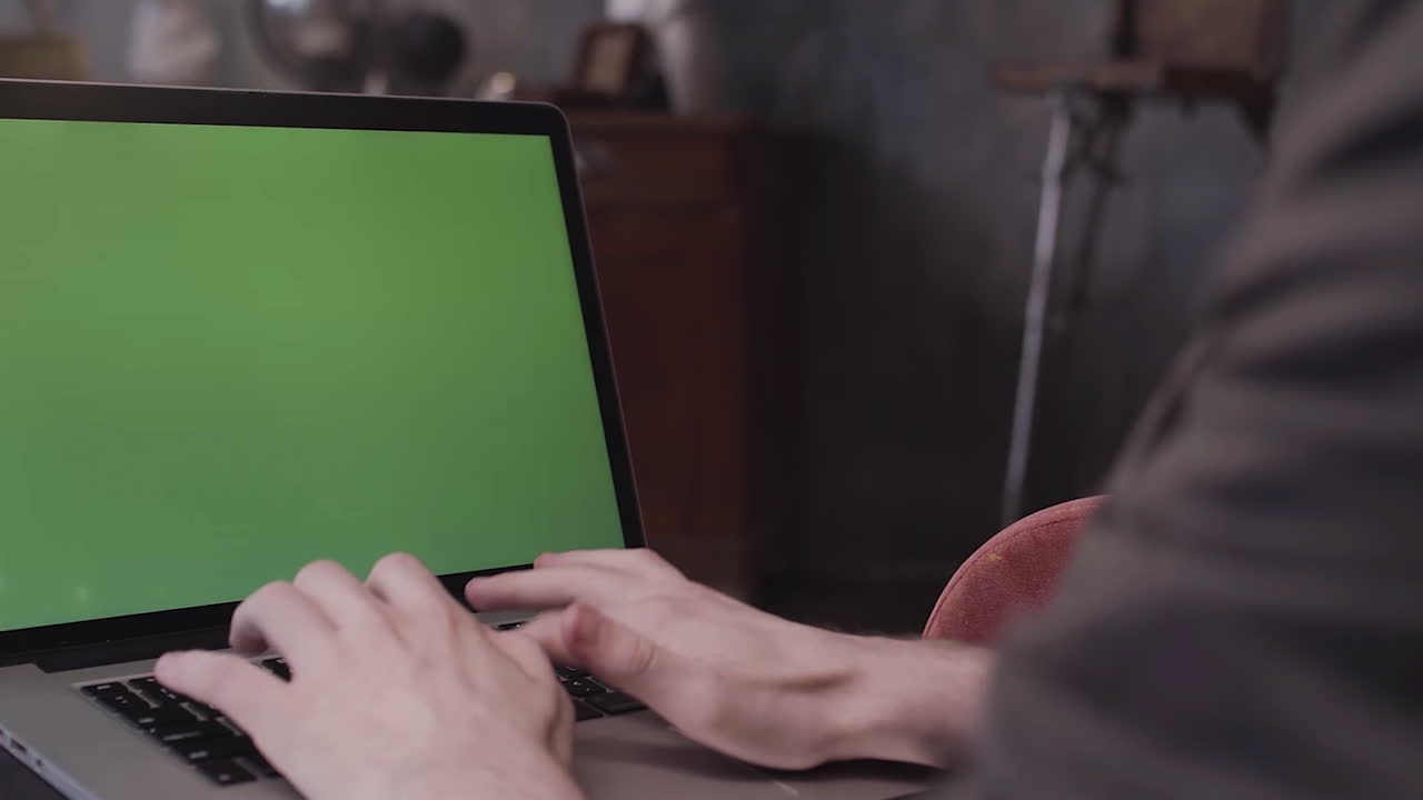 persona escribiendo en una computadora portátil con pantalla verde