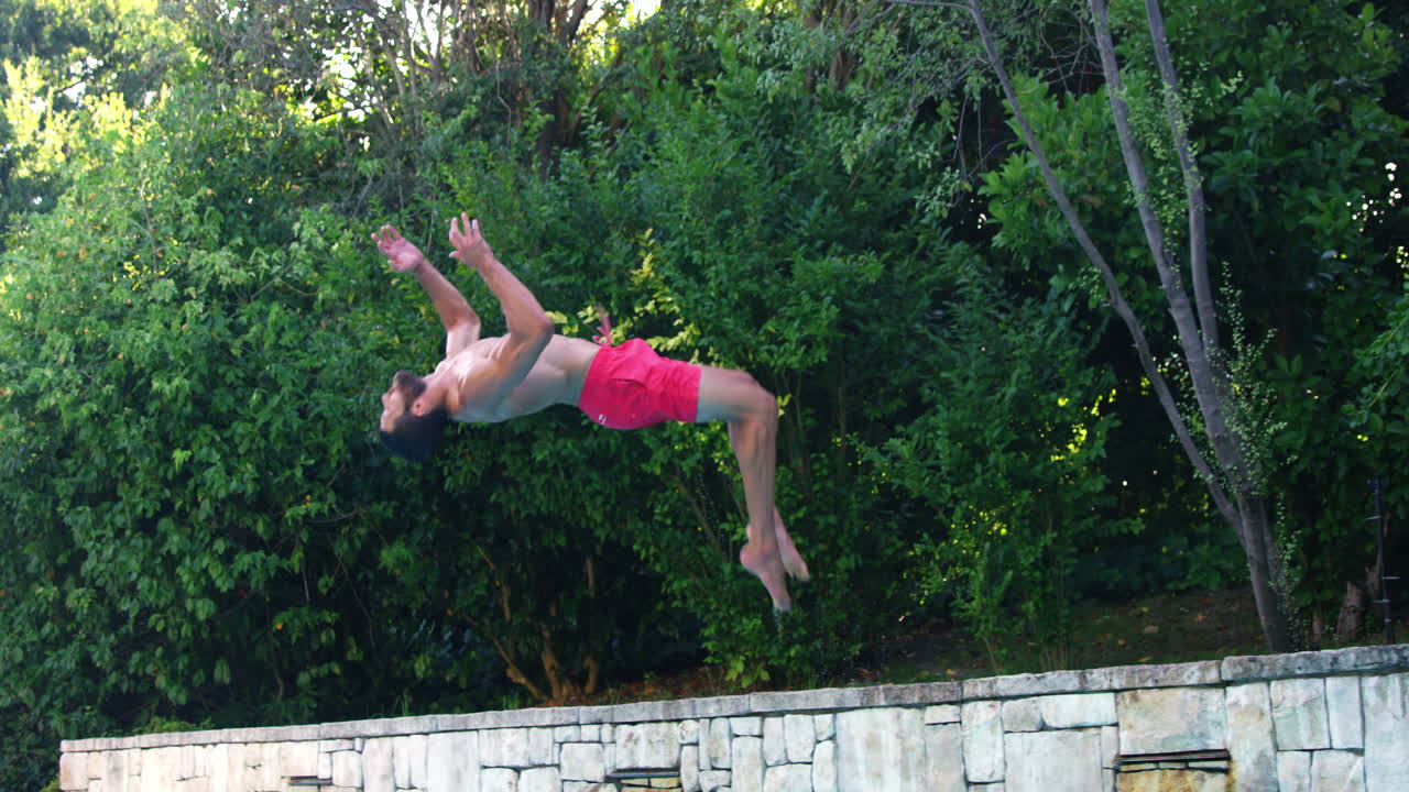 hombre guapo haciendo una salto mortal en la piscina