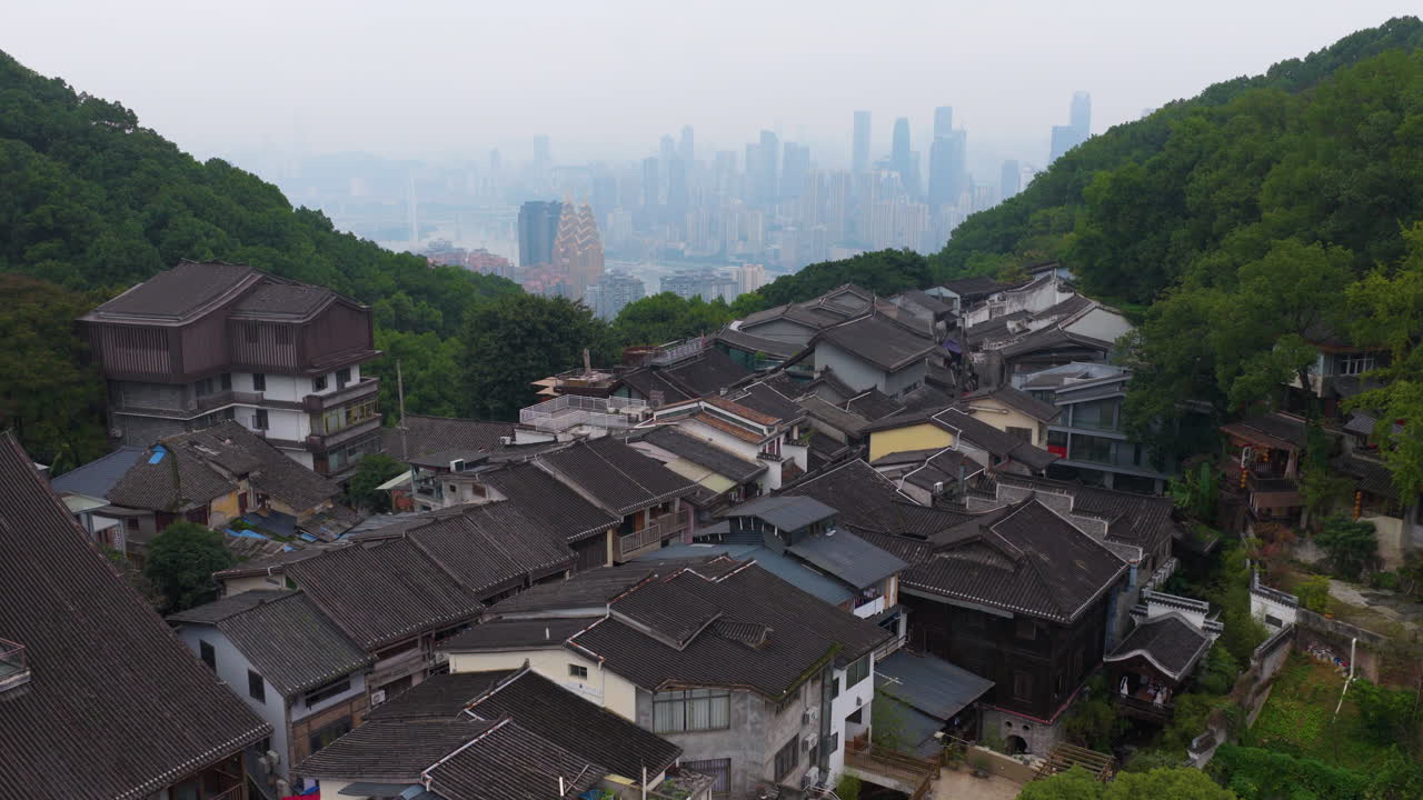 Vista aerea degli edifici della Vecchia Via Huangjueya con lo skyline moderno della città sullo sfondo a Chongqing, Cina. - ripresa in ascesa.