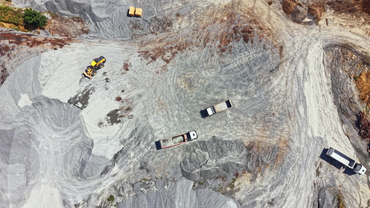Granite quarry operations with trucks and machinery working on site