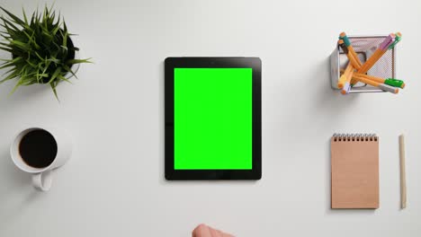 un dedo desplazándose en la pantalla táctil verde