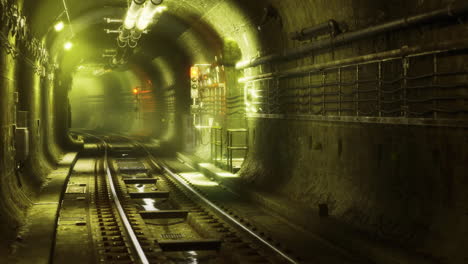 Mysterious underground tunnel with railway tracks and dim lighting at night