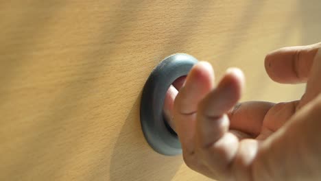 finger in a hole in wooden surface