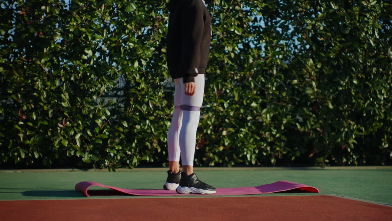 야외에서 저항 밴드로 다리 운동을 하는 여자