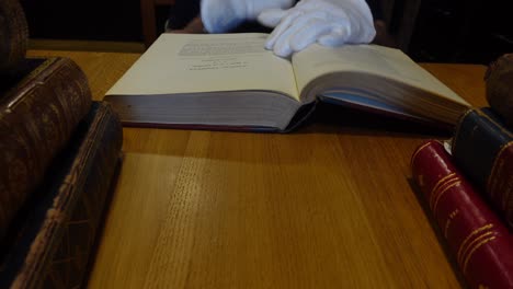 man's hands leafing through an old book in the library