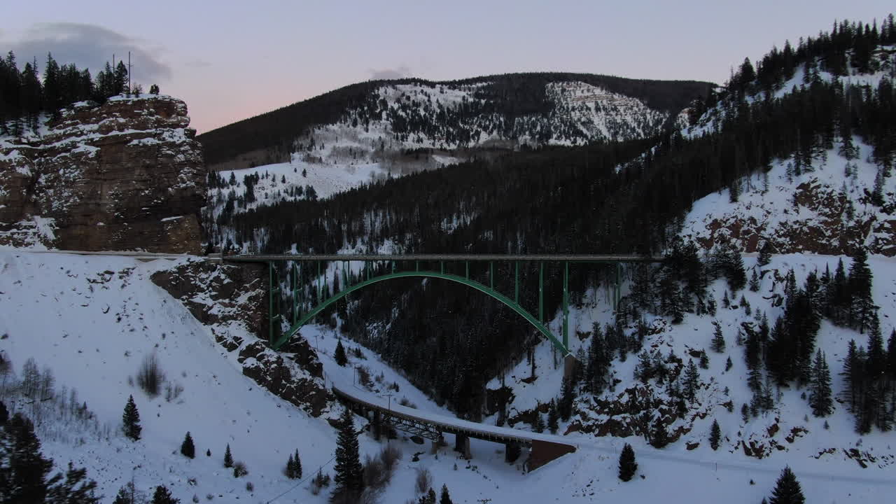 공중 영화 드론 베일 에이번 레드 클리프 상징적인 콜로라도 다리 겨울 중 눈 늦은 일몰 오른쪽 움직임을 확대
