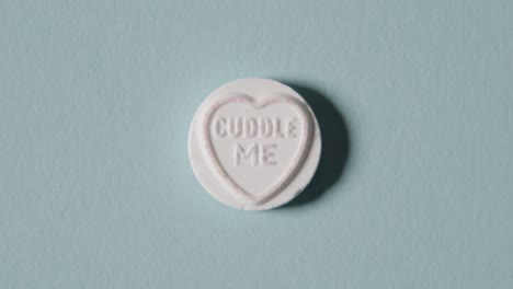 heart candy with cuddle me message on blue background