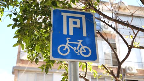 Bicycle-parking-only-blue-signage-under-tree