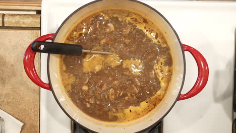 sopa de champiñones de arroz salvaje en un rico caldo hirviendo en la estufa - vista aérea en cámara lenta serie de arroz salvaje