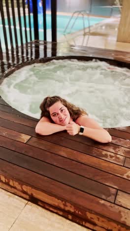 content woman relaxing at edge of hot tub