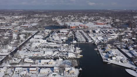 A-drone-view-over-Bay-Shore,-NY's-inlet-on-a-bright-day-after-a-recent-snowfall