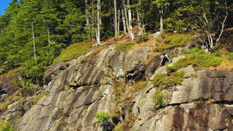 aerial footage as lone climber makes his way to the top of cliff in maine