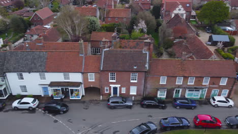 Sideways-Slider-Aerial-Drone-Shot-of-Beautiful-Old-Village-Burnham-Market-Shops-and-Houses-on-Sunny-and-Cloudy-Day-North-Norfolk-UK