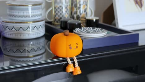 pressing cute pumpkin night light with dangling legs – cozy 4k close-up shot