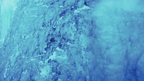 snow crystals flowing at iceland at frozen waterfall on a chilly winter