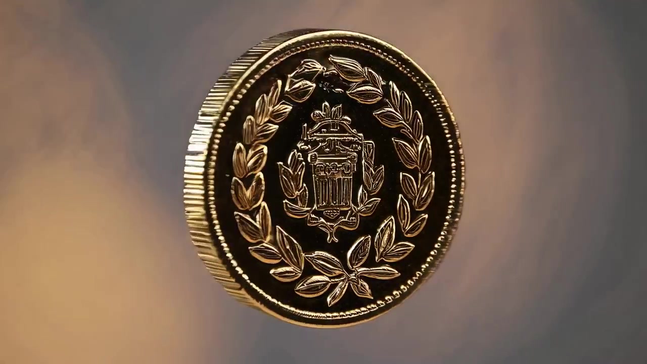Moneta d'oro con emblema e corona d'alloro che ruota su uno sfondo sfocato.