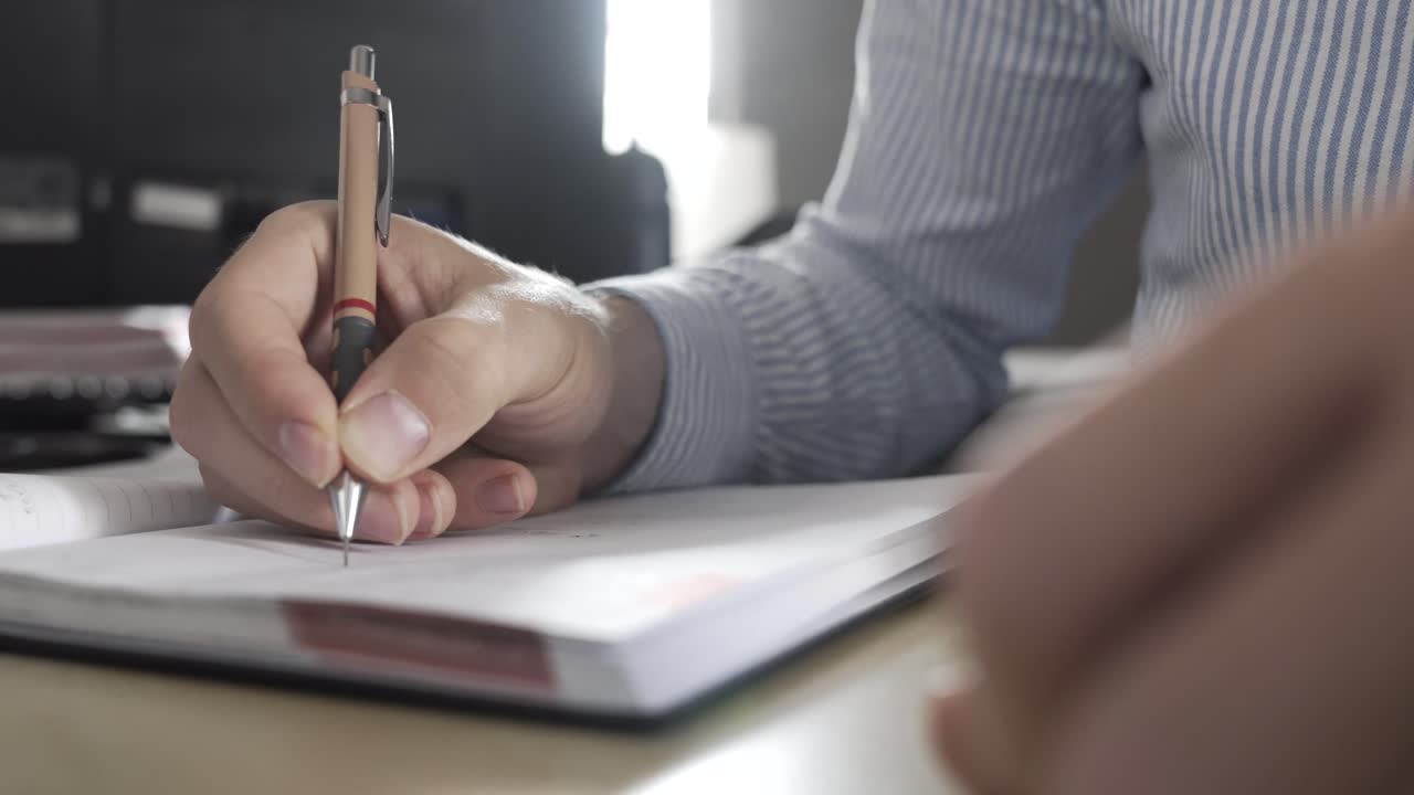 Man writing notes in an office, making business plans