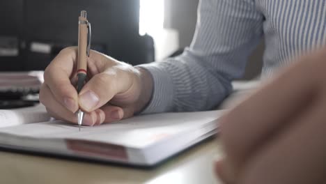hombre escribiendo notas en una oficina, haciendo planes de negocios