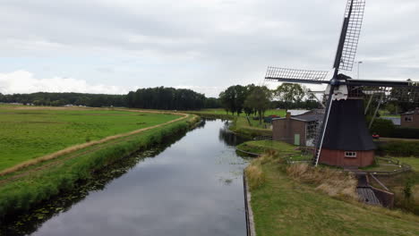 aerial-view-traveling-in-over-a-water-mill-in-the-town-of-De-Groeve,-the-Netherlands