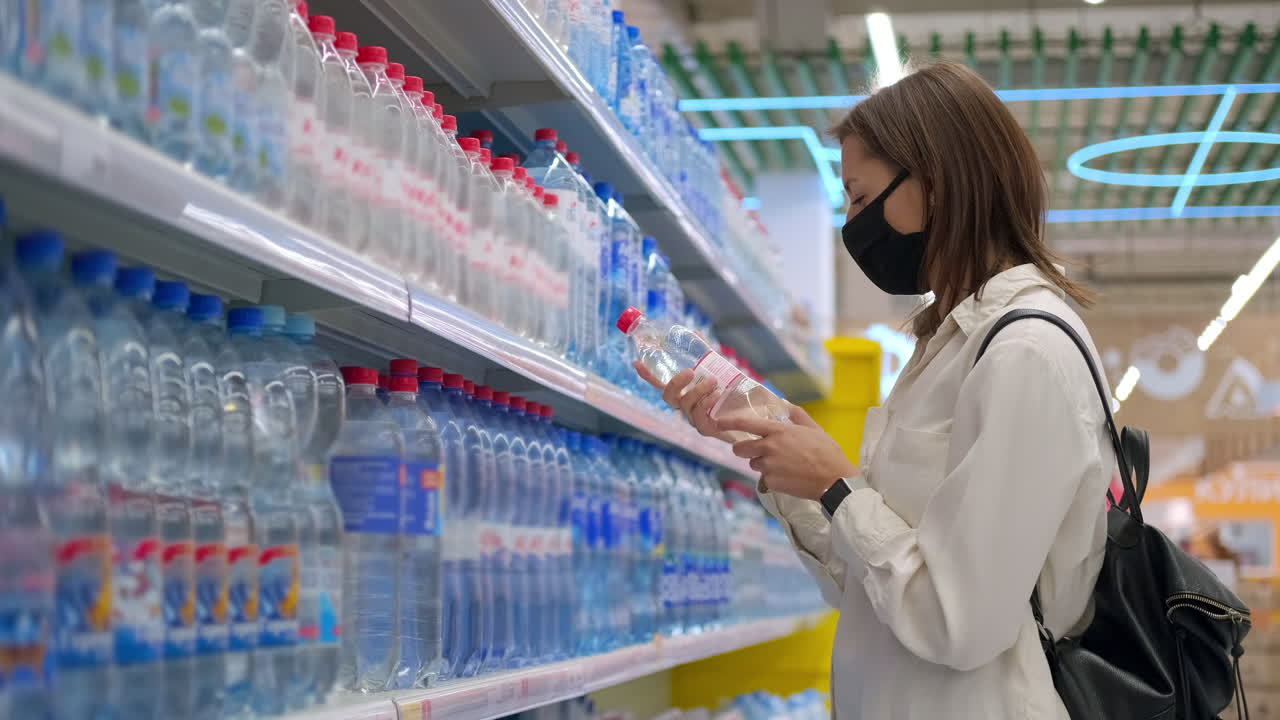 슈퍼마켓 에서 물 을 구입 하는 여자