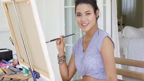 attractive female artist working on a canvas