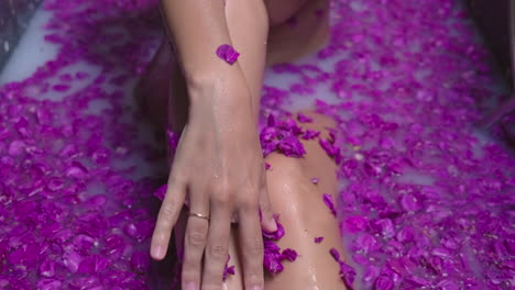 mujer relajándose en un baño de leche con pétalos de rosa