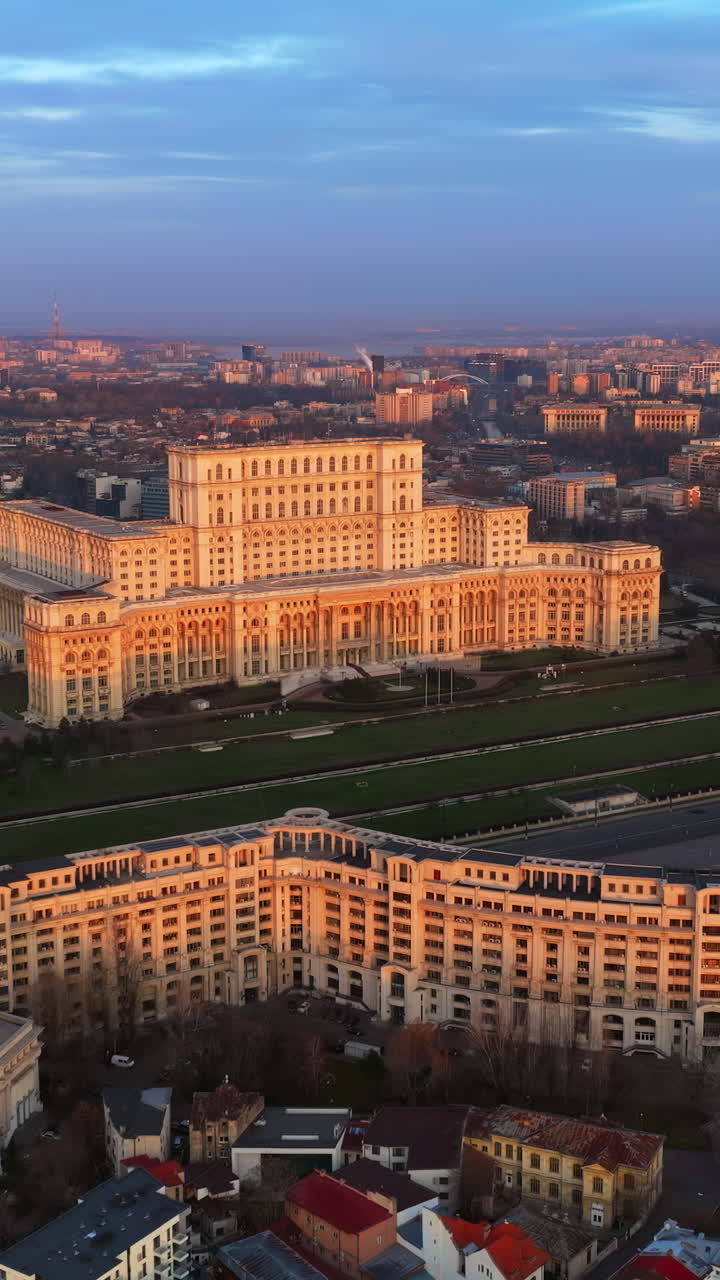 Vertical aerial drone view of Palace of the Parliament in Bucharest downtown at sunset. Blue hour. Romania
