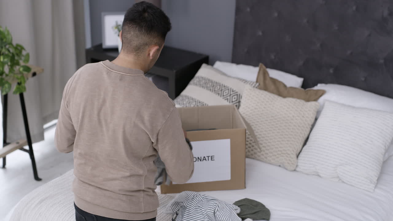 기부 상자 에 옷 을 포장 하는 사람