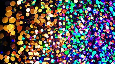 las partículas de brillo de varios colores crean una exhibición hipnotizante, brillando y brillando contra un fondo oscuro, añadiendo un toque de magia y vitalidad