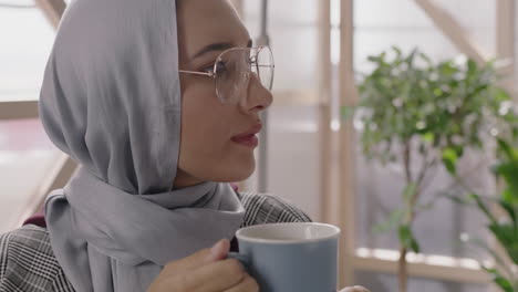 close up portrait beautiful muslim business woman drinking coffee relaxing on lunch break enjoying successful career lifestyle wearing traditional hijab headscarf in modern office workplace