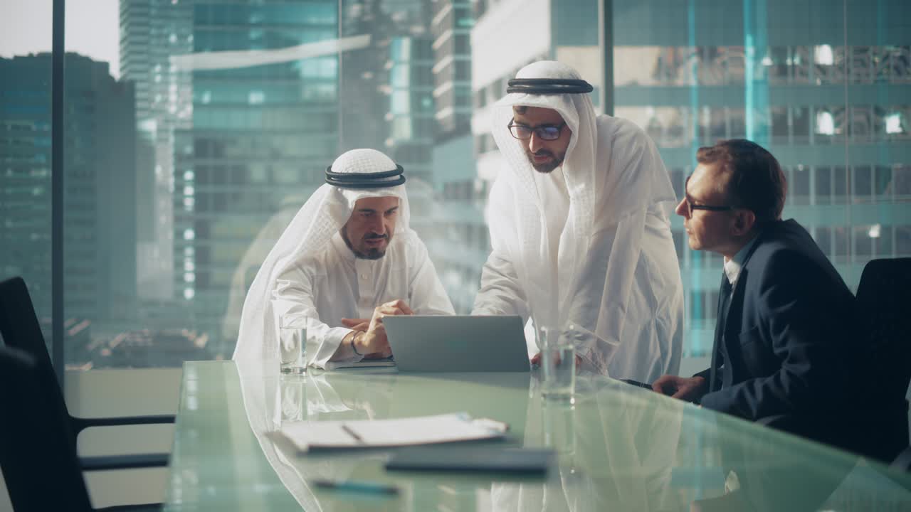 국제 비즈니스 컨설턴트는 성공적인 아랍 회사 소유자에게 금융 전략 계획에 대해 조언합니다. 현대 사무실에서 미국인과 사우디 사업가 사이의 다문화 회의.