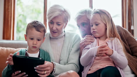 children, grandparents and tablet on sofa