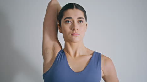 focused woman training alone at white home closeup. sport girl stretching hands