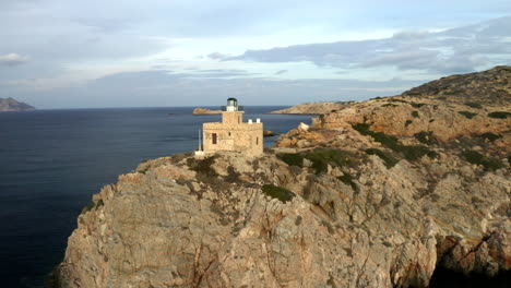 circling drone aerial footage of lighthouse on a peninsula in the mediterranean on the island of ios, greece