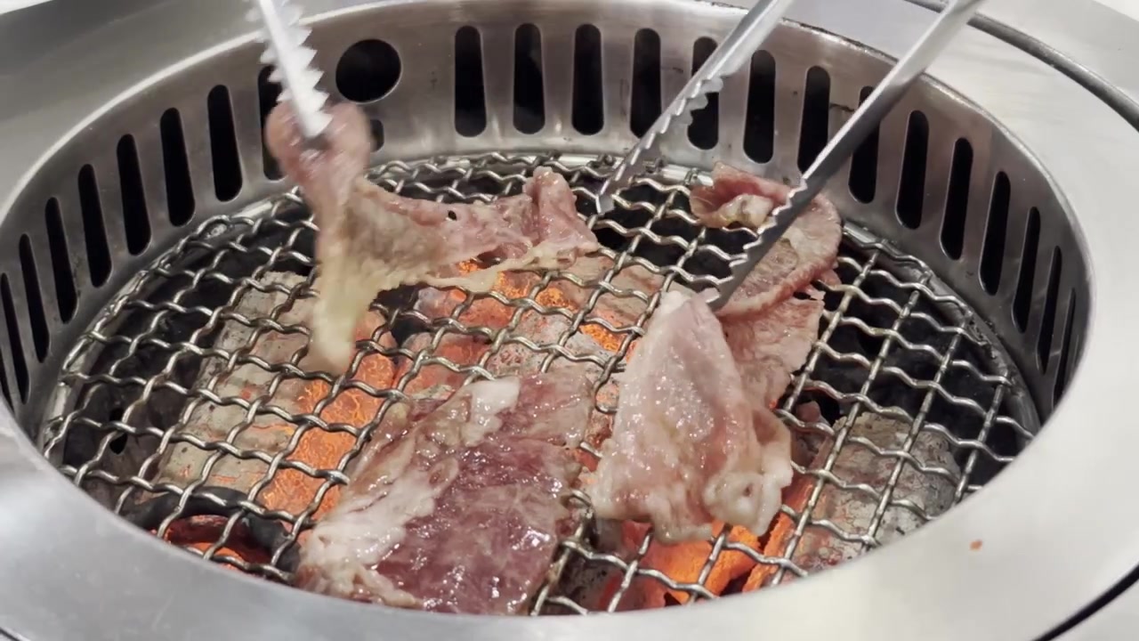Close-up daging sapi Wagyu A5 premium yang dipanggang di atas panggangan barbekyu panas, menampilkan marbling yang kaya, tekstur mendesis, dan pengalaman bersantap gourmet