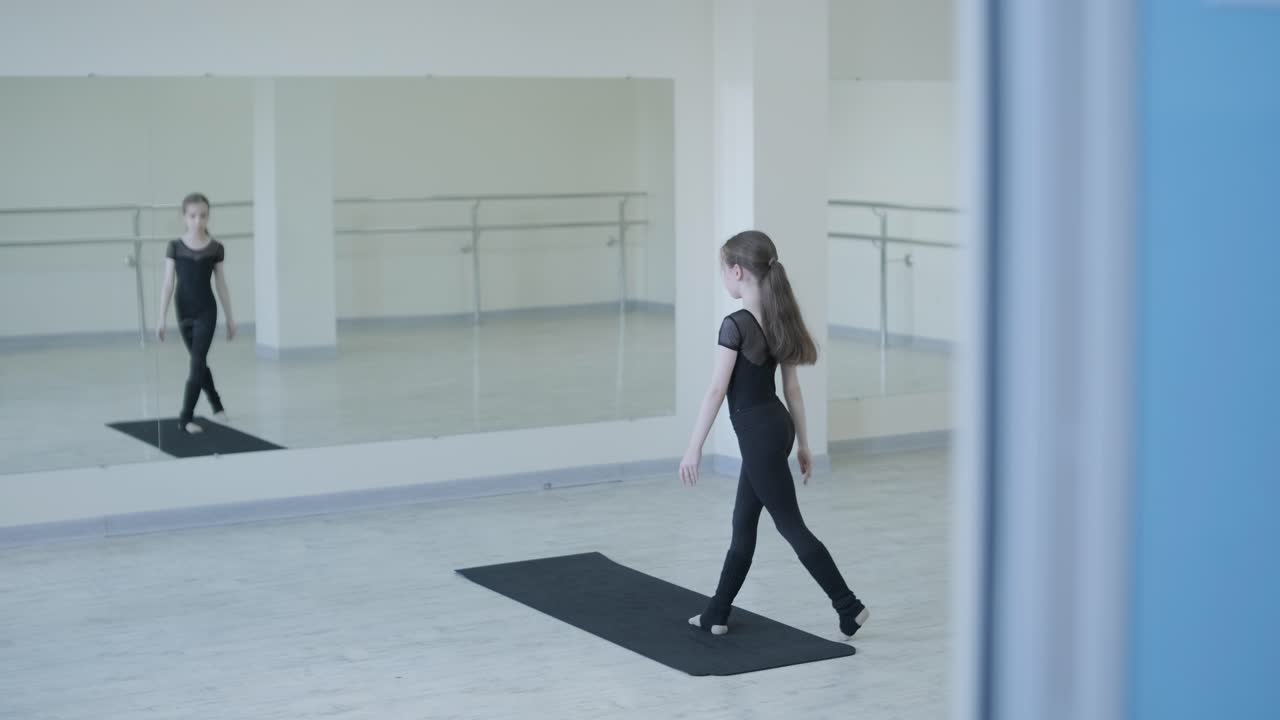 젊은 발레리나 가 스튜디오 에서 춤 을 연습 하고 있다
