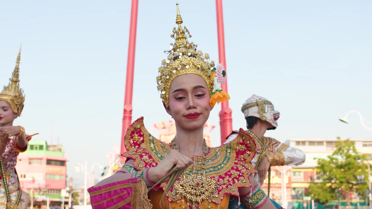 Una ballerina esegue movimenti tradizionali Khon in un costume sontuoso in un tempio di Bangkok.