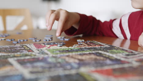 El-Primer-Plano-De-Las-Manos-De-Los-Niños-Ensambla-El-Rompecabezas-Para-Divertirse,-Disfrutar-Del-Juego-En-Casa-Sentado-En-La-Mesa-En-La-Sala-De-Estar