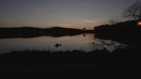 Imágenes-De-Drones-De-Silueta-De-Un-Pescador-En-El-Lago-Al-Atardecer